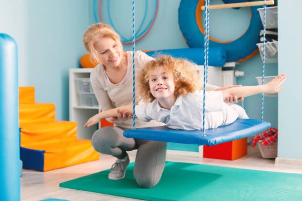 Therapist guiding a child with autism through occupational therapy exercises